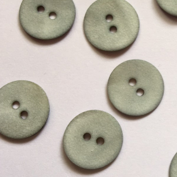 Matt pale grey/blue shell button